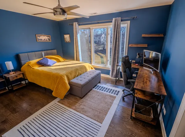 a bedroom with a bed and wooden floor