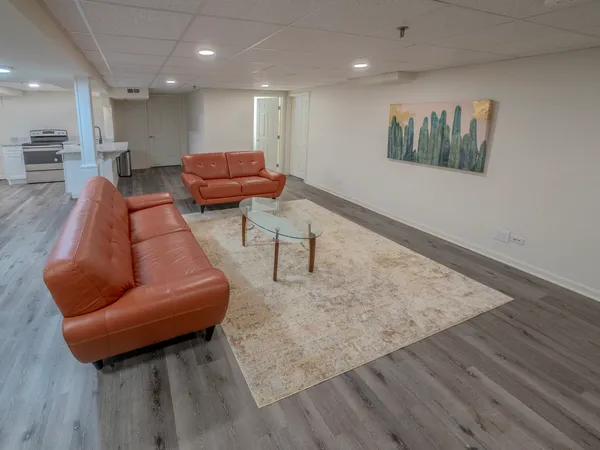 a living room with furniture and a wooden floor
