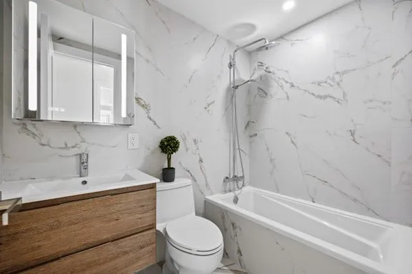 a bathroom with a sink a toilet and shower