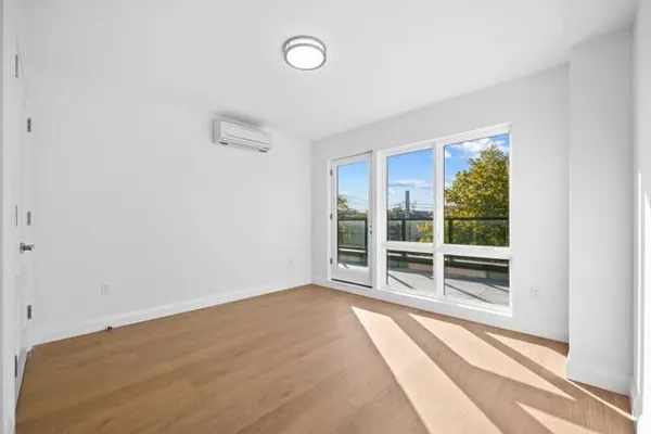 a view of a room with wooden floor and a window