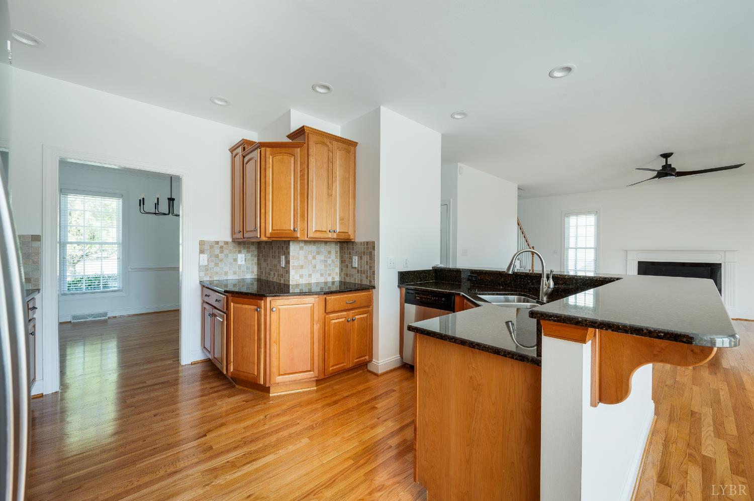 1166 Caperton Way Forest, VA 24551 - Photo 14 of 59 a kitchen with stainless steel appliances granite countertop wooden floors and white cabinets