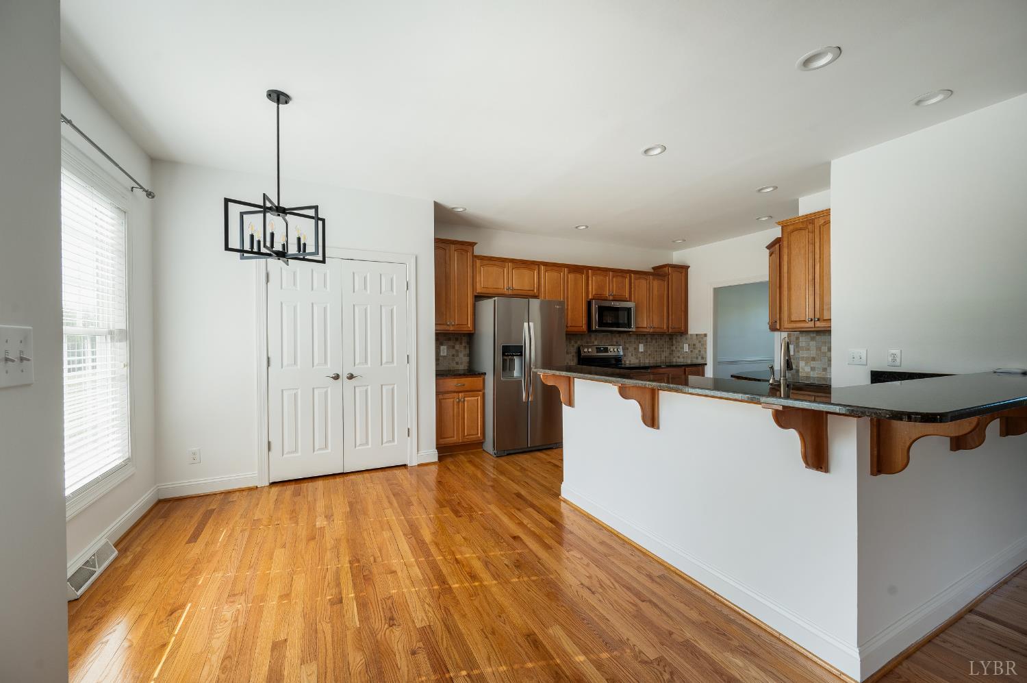 1166 Caperton Way Forest, VA 24551 - Photo 16 of 59 a view of a kitchen with kitchen island wooden floors stainless steel appliances and windows