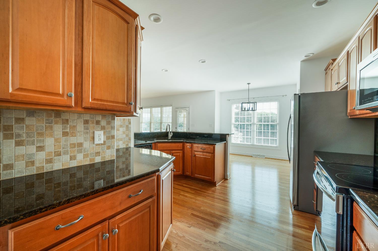 1166 Caperton Way Forest, VA 24551 - Photo 10 of 59 a kitchen with stainless steel appliances granite countertop wooden cabinets a stove a sink and dishwasher with wooden floor