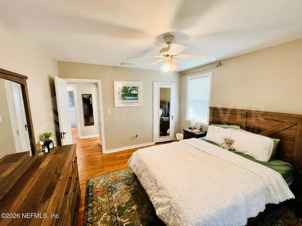 a bedroom with bed and wooden floor