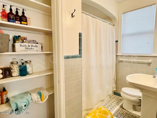 a bathroom with a toilet and shower curtain