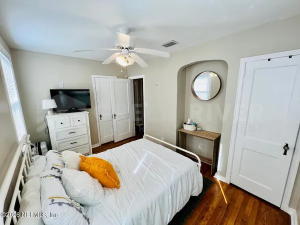 a bedroom with a bed and a flat screen tv