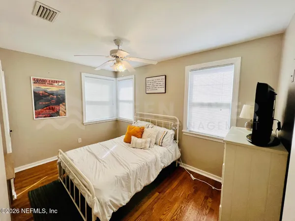 a bedroom with a bed and a flat tv screen on the dresser