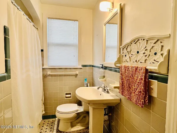 a bathroom with a sink and mirror with toilet