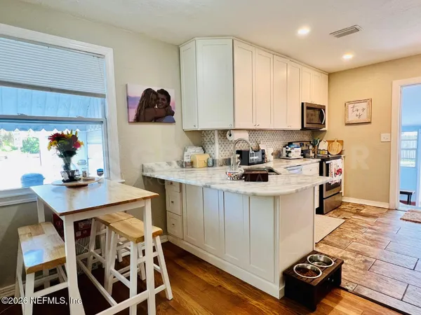 a kitchen with a sink cabinets and wooden floor