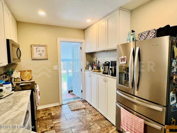 a kitchen with stainless steel appliances granite countertop a refrigerator and a stove top oven