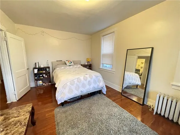 a bedroom with a bed and wooden floor