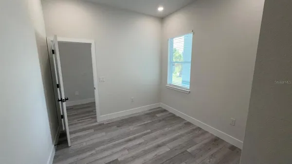 a view of a room with wooden floor and white doors