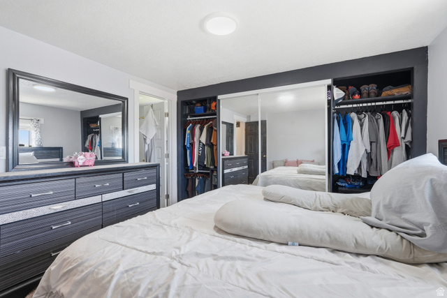 2500 North Fort Lane, Unit 220 Layton, UT 84041 - Photo 11 of 23 Bedroom featuring a built-in closet system with mirrored sliding doors, integrated shelving, and hanging rods
