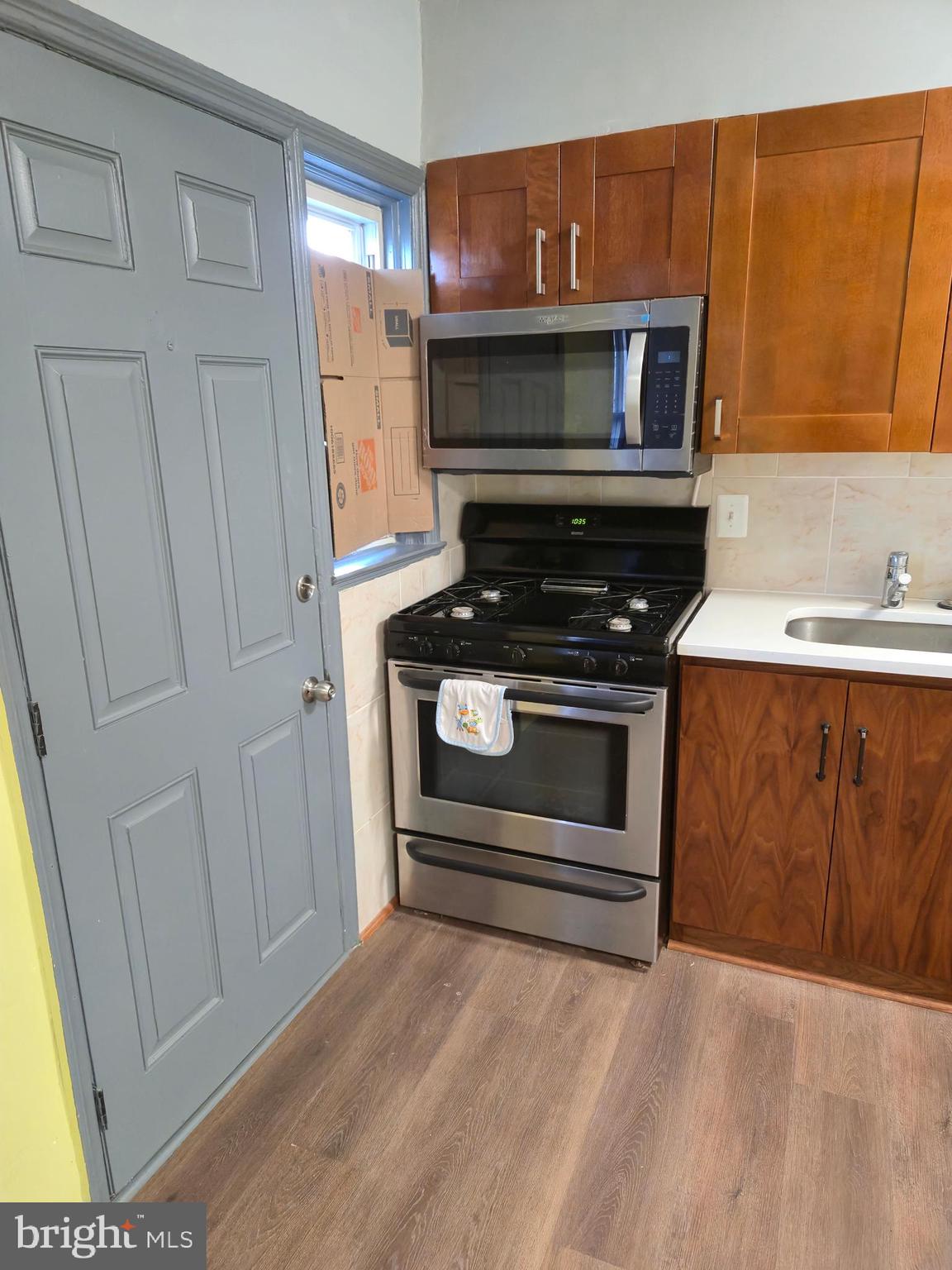 721 Roundview Road Baltimore, MD 21225 - Photo 18 of 30 a kitchen with a stove and a microwave