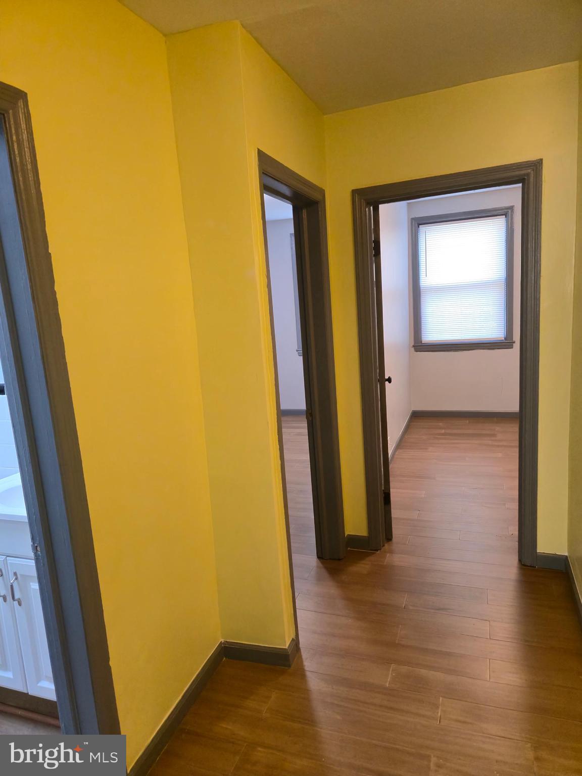 721 Roundview Road Baltimore, MD 21225 - Photo 22 of 30 a view of an empty room with wooden floor and a window