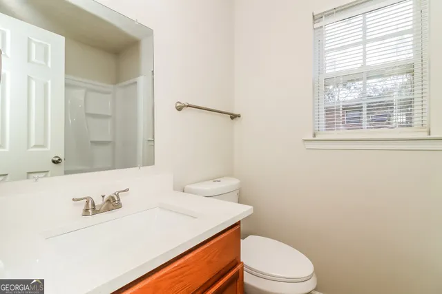 a bathroom with a sink a toilet and a mirror