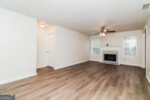 a view of empty room with wooden floor and fireplace