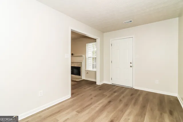 a view of an empty room with wooden floor