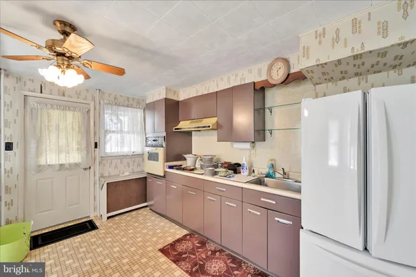 a kitchen with stainless steel appliances a sink a refrigerator and cabinets