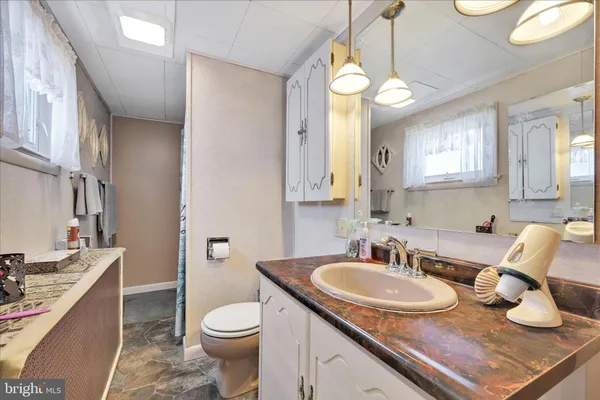 a bathroom with a granite countertop sink and a mirror