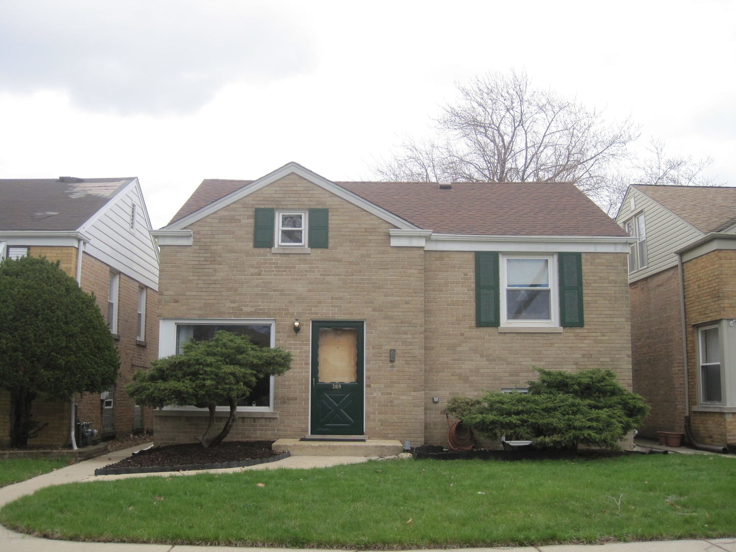 a front view of a house with a yard and trees