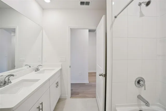a bathroom with a double vanity sink a mirror and shower