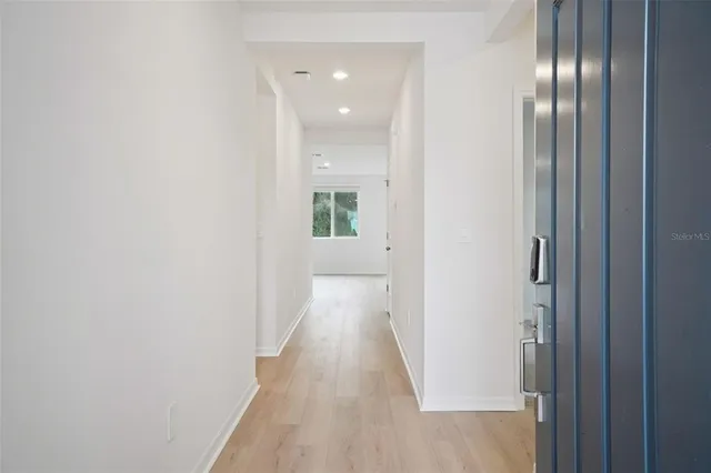 a view of a hallway with wooden floor
