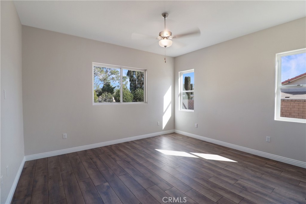 14785 Tigertail Road Apple Valley, CA 92307 - Photo 16 of 20 a view of an empty room with wooden floor and a window