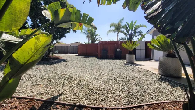 a view of a patio with table and chairs potted plants