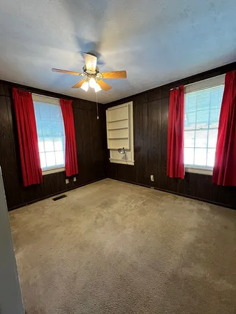 a view of a room with large windows and chandelier