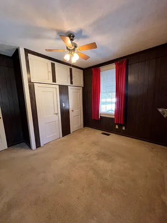 a view of empty room with windows and refrigerator