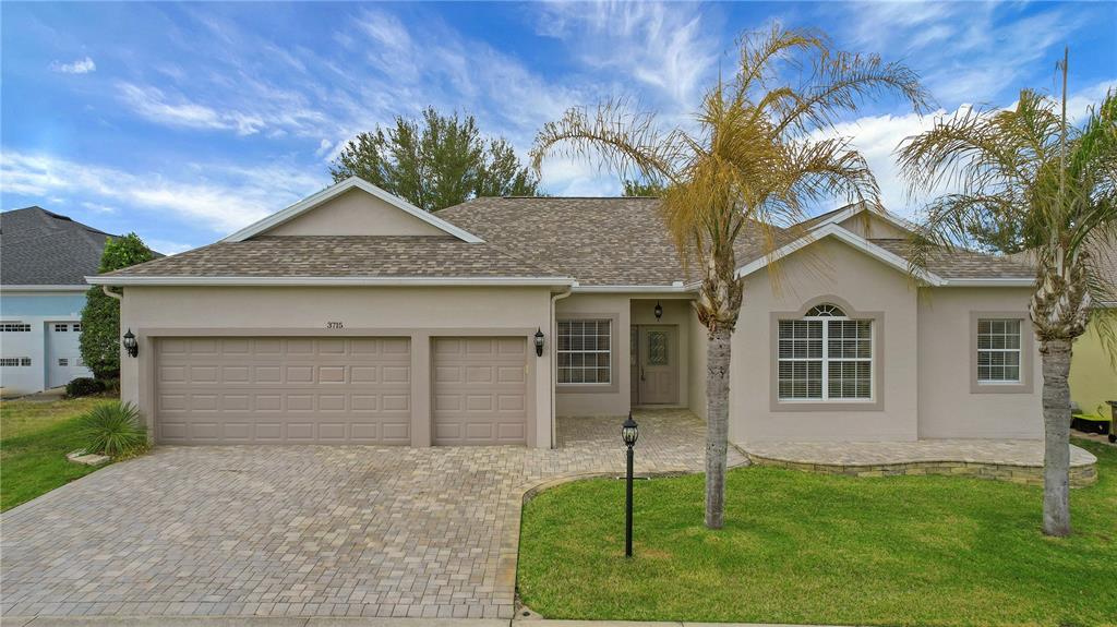 3715 Mulberry Grove Loop Leesburg, FL 34748 - Photo 1 of 48 a front view of a house with a garden and yard