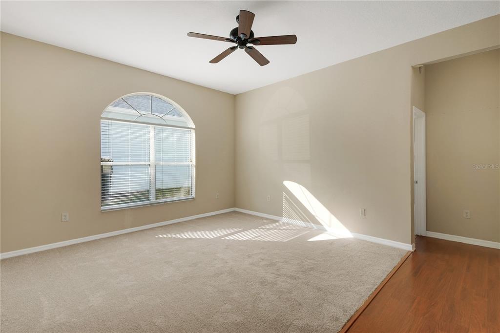 3715 Mulberry Grove Loop Leesburg, FL 34748 - Photo 12 of 48 an empty room with windows and chandelier fan