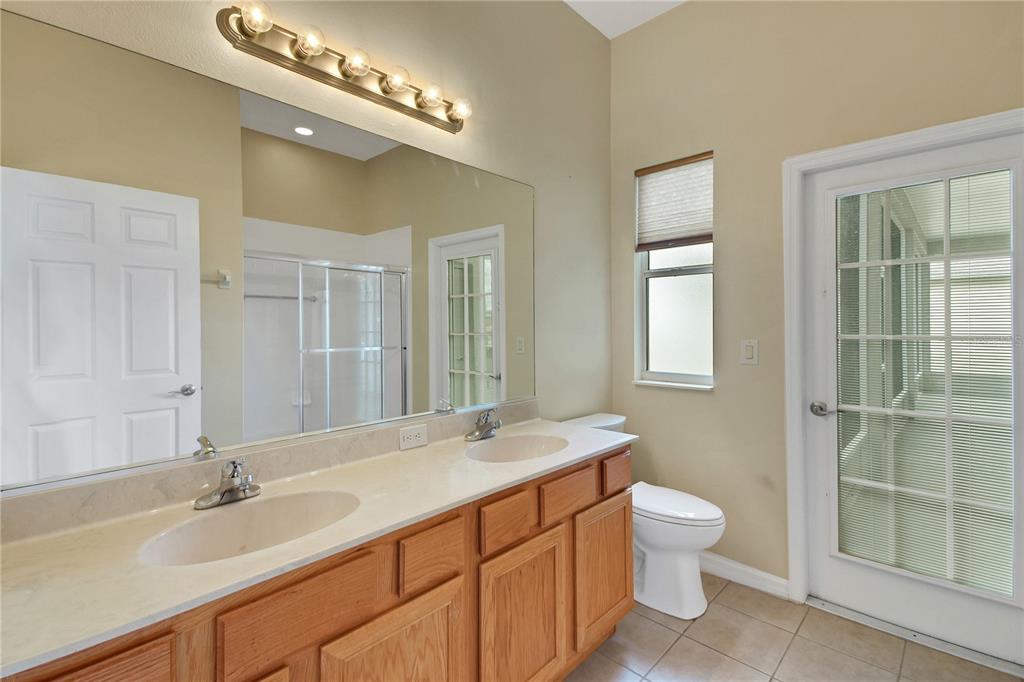 3715 Mulberry Grove Loop Leesburg, FL 34748 - Photo 19 of 48 a bathroom with a double vanity sink a toilet and a mirror