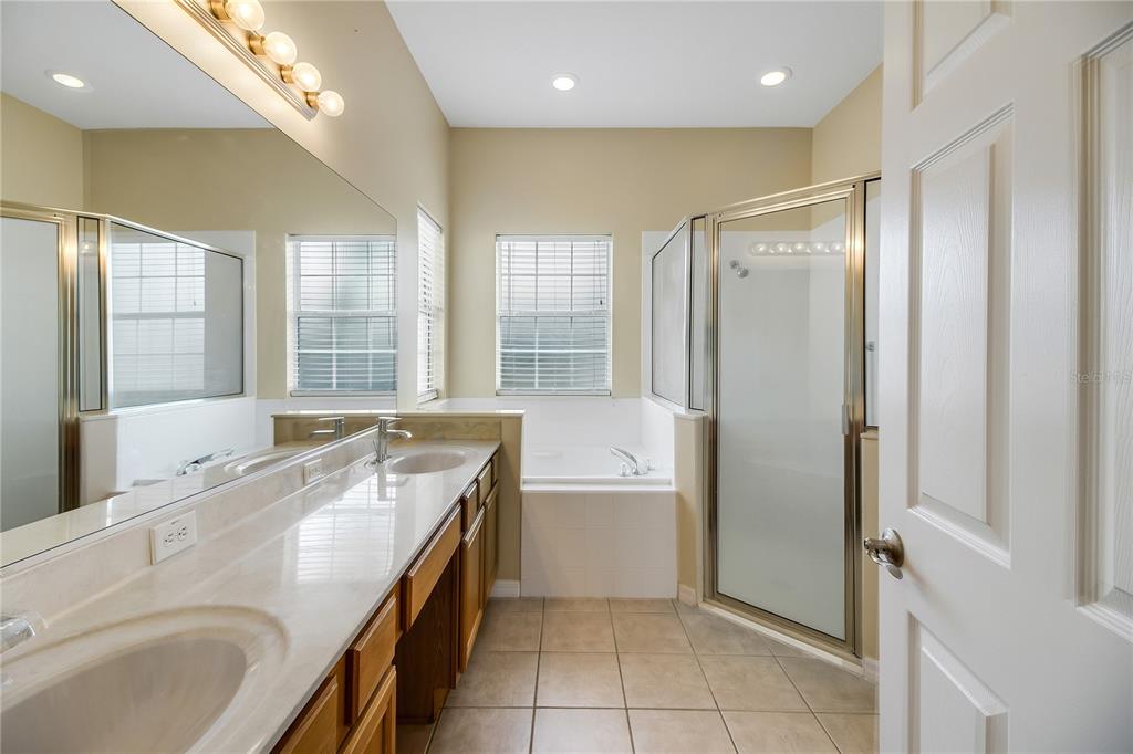 3715 Mulberry Grove Loop Leesburg, FL 34748 - Photo 31 of 48 a bathroom with a granite countertop tub sink shower and mirror