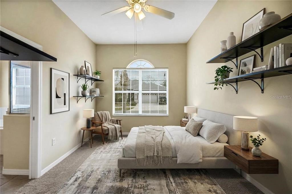 3715 Mulberry Grove Loop Leesburg, FL 34748 - Photo 37 of 48 a spacious bedroom with a bed couch and a window