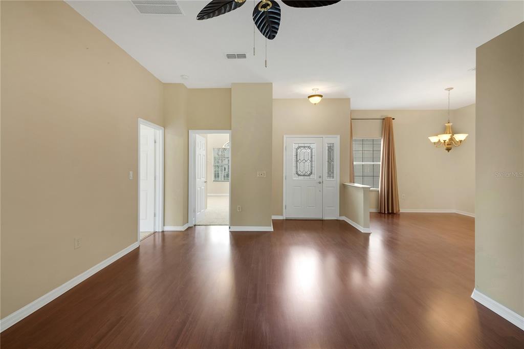 3715 Mulberry Grove Loop Leesburg, FL 34748 - Photo 4 of 48 a view of an empty room with wooden floor and a ceiling fan