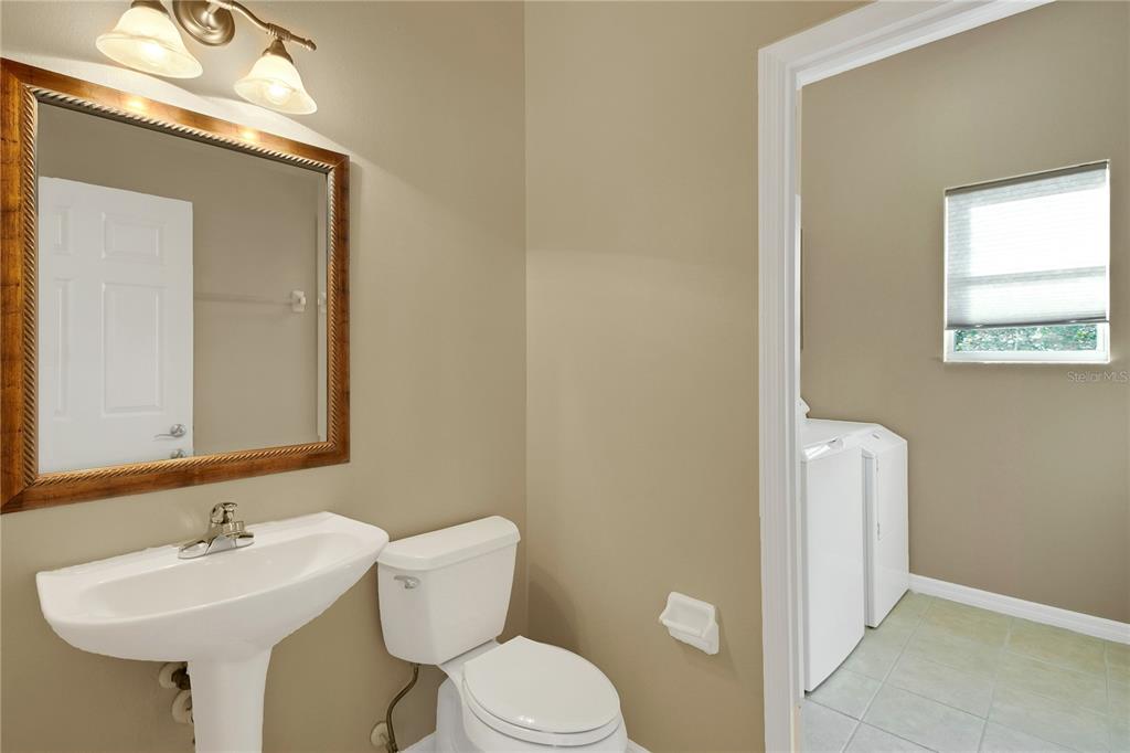 3715 Mulberry Grove Loop Leesburg, FL 34748 - Photo 42 of 48 a bathroom with a toilet sink and mirror