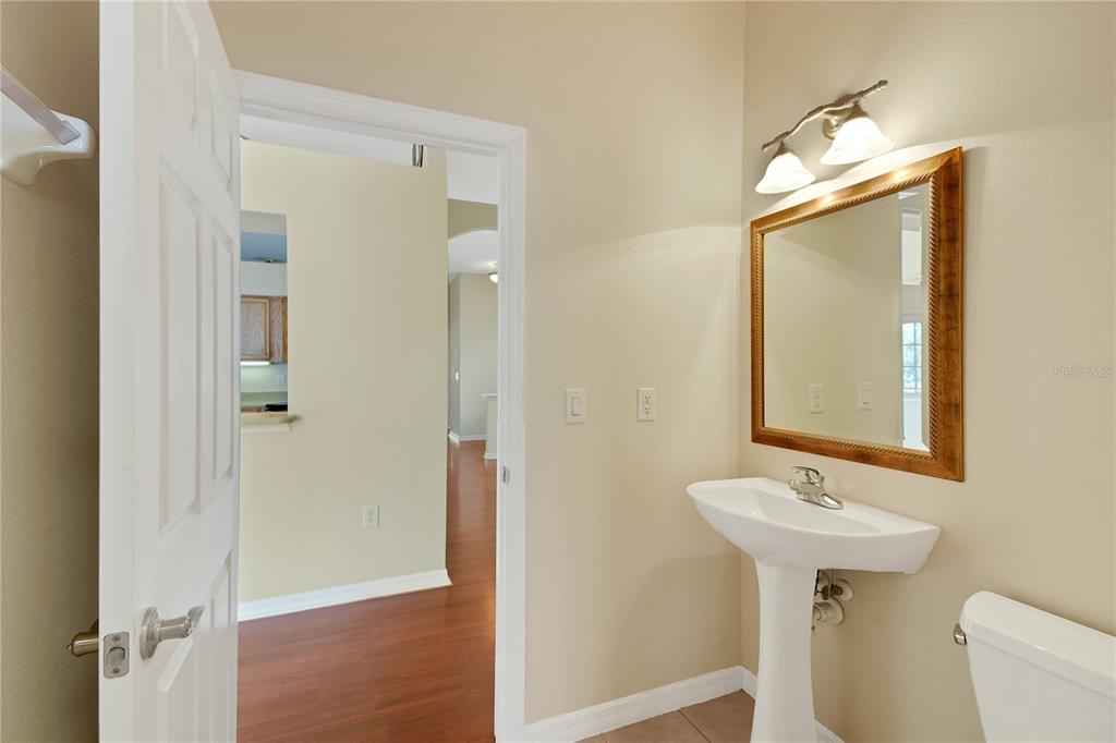3715 Mulberry Grove Loop Leesburg, FL 34748 - Photo 44 of 48 a bathroom with a sink a mirror a toilet and shower