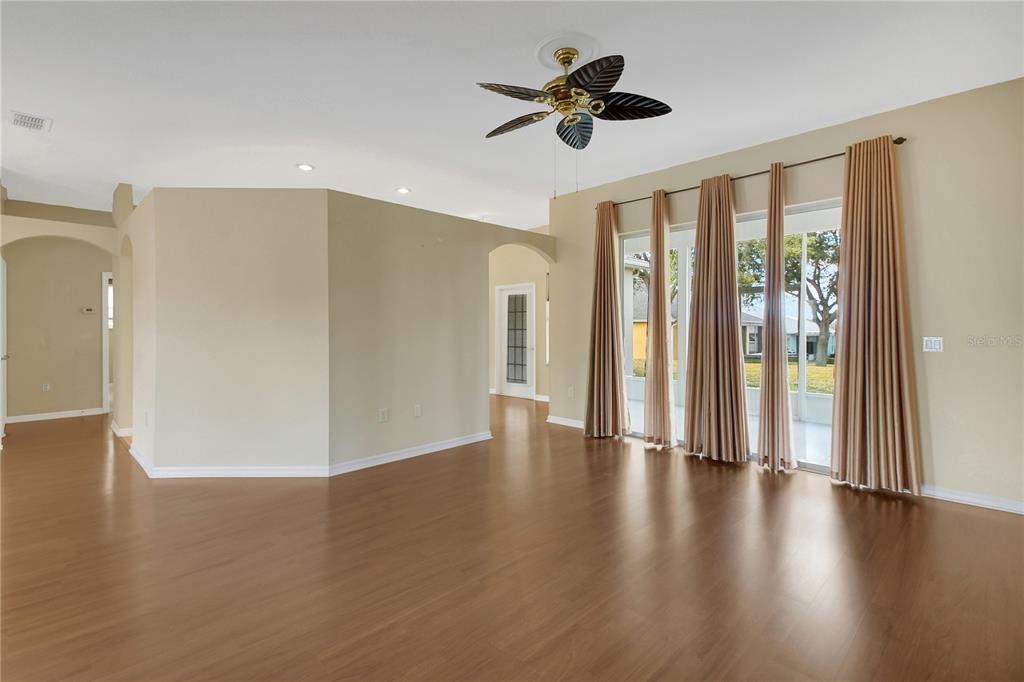 3715 Mulberry Grove Loop Leesburg, FL 34748 - Photo 6 of 48 a view of an empty room with wooden floor and a window