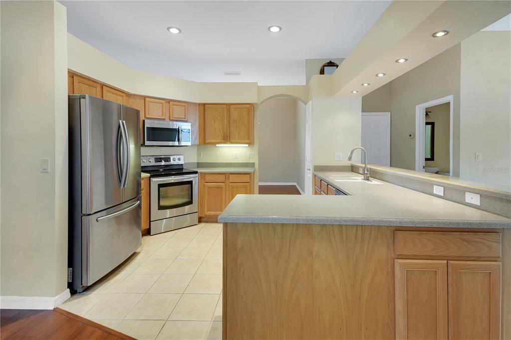 3715 Mulberry Grove Loop Leesburg, FL 34748 - Photo 7 of 48 a kitchen with kitchen island granite countertop counter top space appliances and a sink