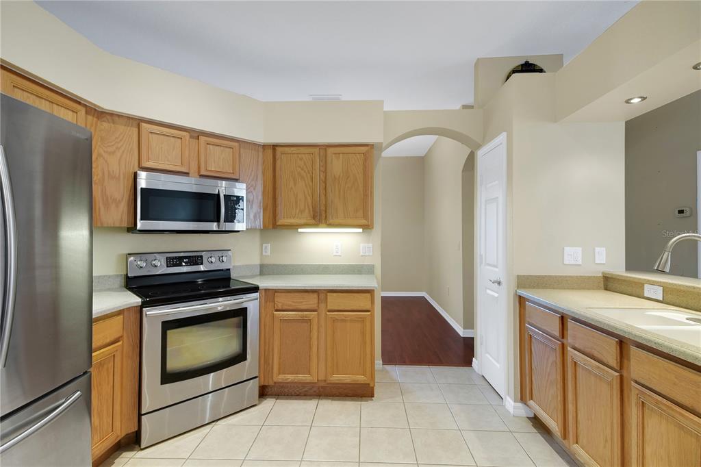 3715 Mulberry Grove Loop Leesburg, FL 34748 - Photo 8 of 48 a kitchen with stainless steel appliances granite countertop a sink stove and refrigerator