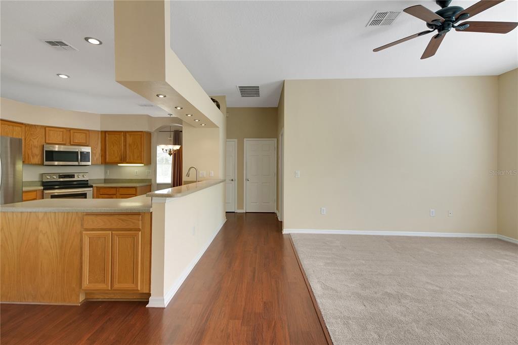 3715 Mulberry Grove Loop Leesburg, FL 34748 - Photo 10 of 48 a view of a kitchen with a sink and wooden floor