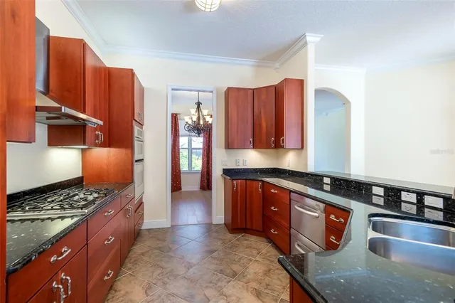 a kitchen with stainless steel appliances granite countertop a stove a sink dishwasher and cabinets with wooden floor