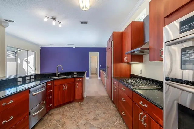 a kitchen with stainless steel appliances granite countertop a stove a sink and a refrigerator