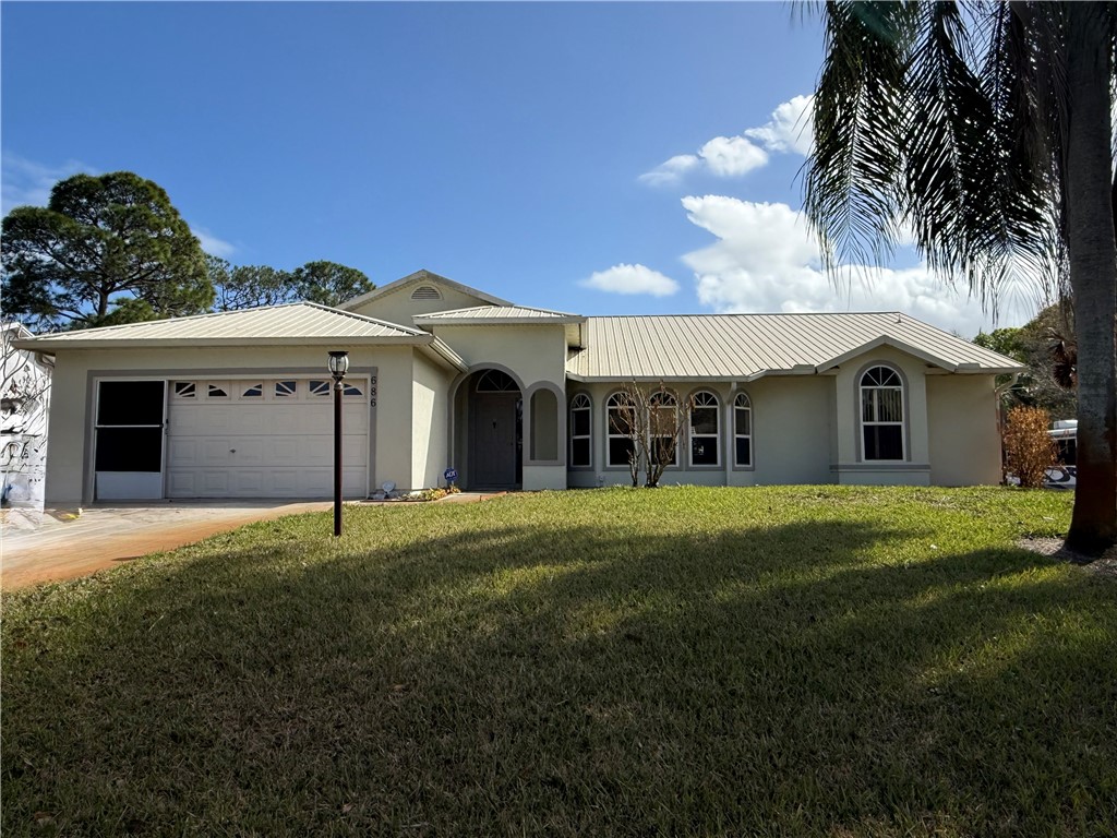 686 Caravan Terrace Sebastian, FL 32958 - Photo 2 of 24 a front view of a house with a garden