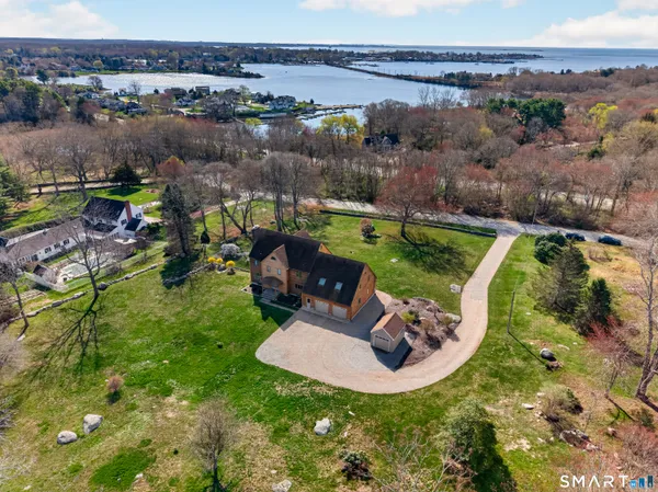 an aerial view of a house with a garden and lake view