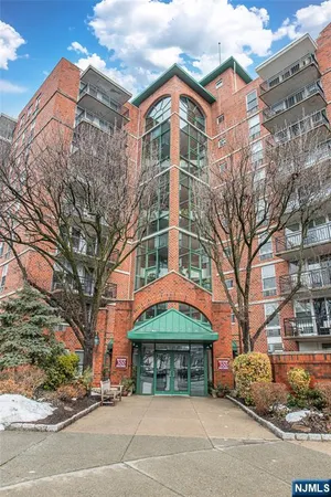 a front view of a building with streets and trees