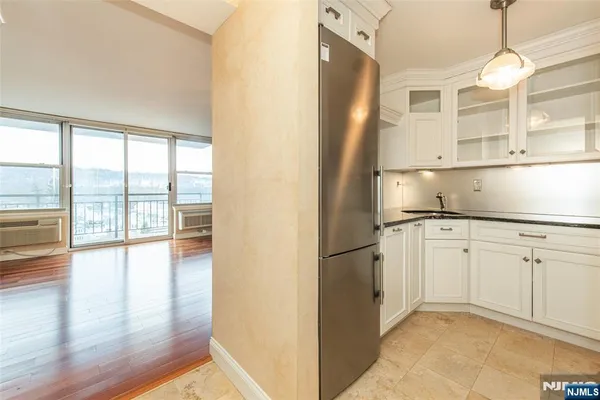 a hallway with white cabinets and wooden floor