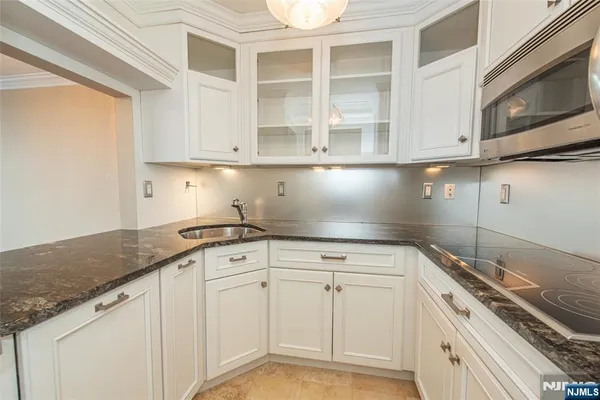a kitchen with granite countertop white cabinets and white appliances